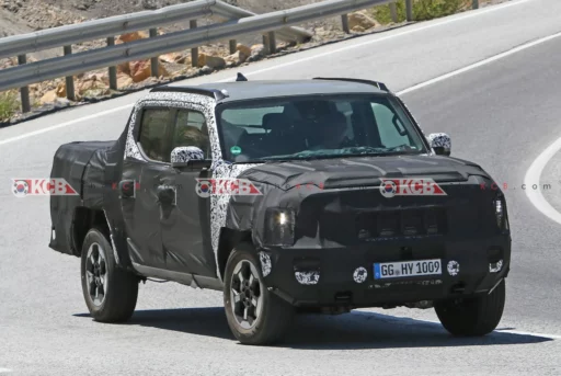 Camioneta negra parcialmente camuflada en prueba de carretera.