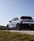 Automóvil moderno en un paisaje campestre bajo un cielo despejado.