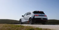 Automóvil moderno en un paisaje campestre bajo un cielo despejado.