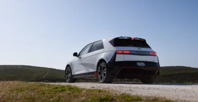 Automóvil moderno en un paisaje campestre bajo un cielo despejado.