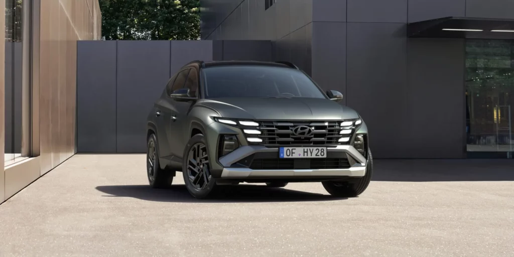 SUV gris estacionado frente a edificio moderno.