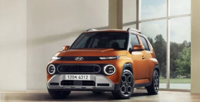 SUV naranja de Hyundai en interior con ventanales grandes.