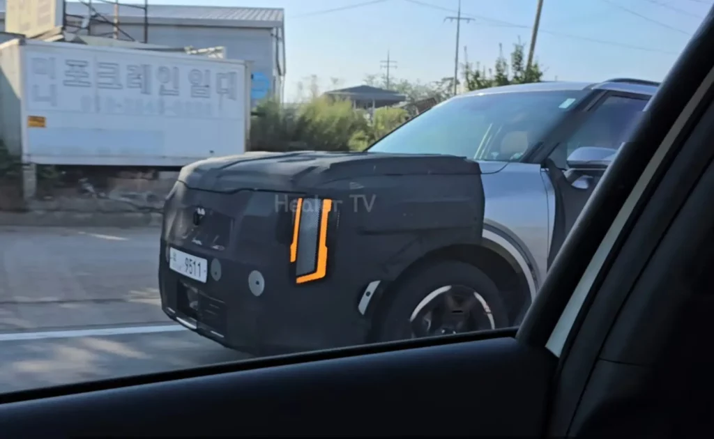 Vehículo camuflado en carretera, posiblemente en pruebas o desarrollo.