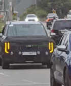 Vehículo en pruebas camuflado circulando por una carretera con tráfico.