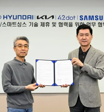 Dos hombres posan con un acuerdo firmado entre Hyundai y Samsung.