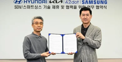 Dos hombres posan con un acuerdo firmado entre Hyundai y Samsung.