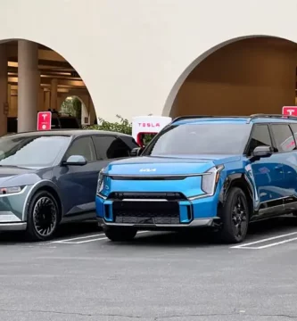 Dos coches eléctricos estacionados frente a estaciones de carga Tesla.