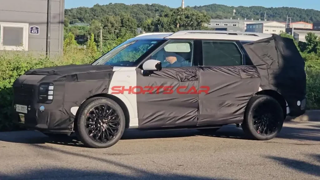 Prototipo de SUV con camuflaje negro siendo probado en la calle.