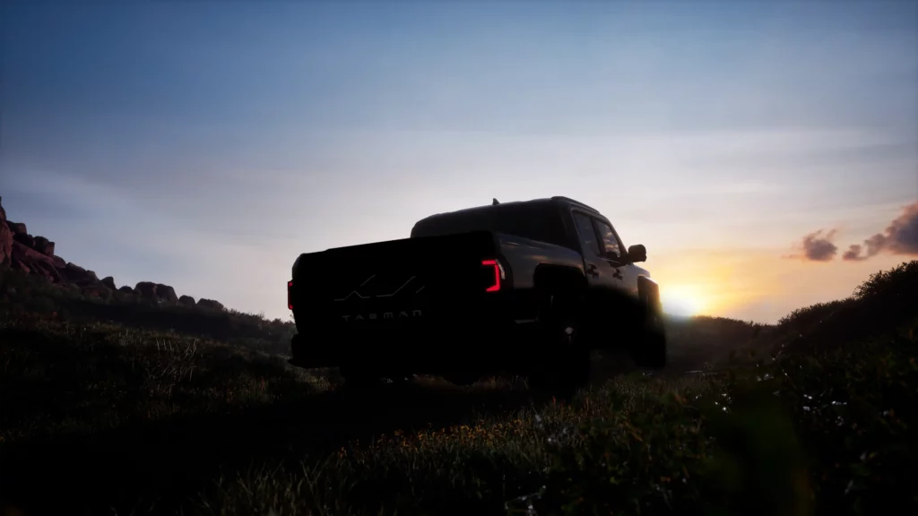 Camioneta negra al atardecer en un paisaje montañoso.