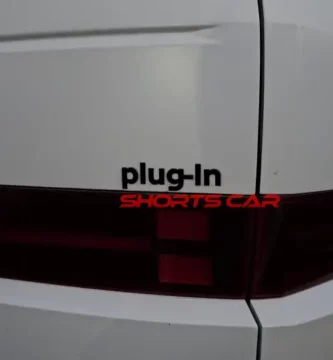 Parte trasera de un coche blanco con etiqueta "plug-in".