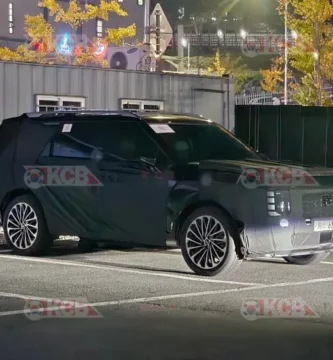 Auto camuflado estacionado en un lote al aire libre.