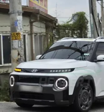 Auto blanco estacionado frente a una tienda antigua.