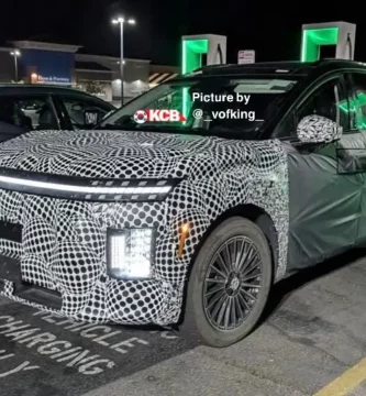 Auto camuflado en estación de carga nocturna.