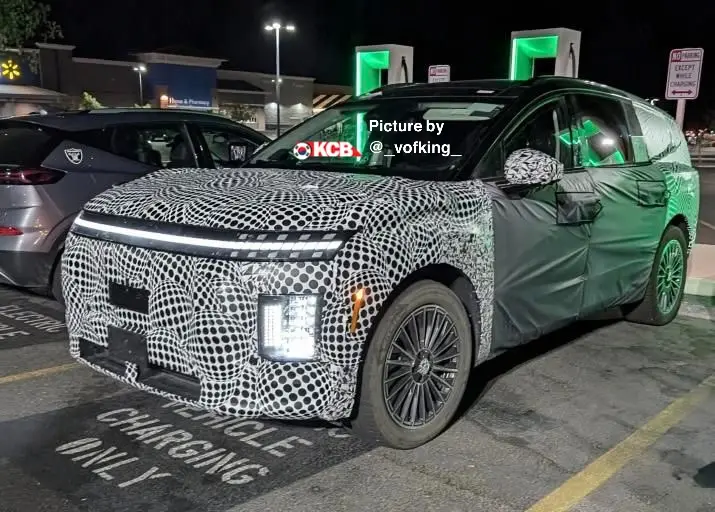 Auto camuflado en estación de carga nocturna.