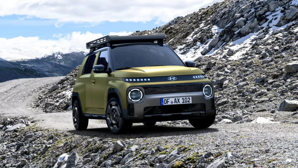 Auto todoterreno verde sobre un camino rocoso en las montañas.