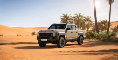 Camioneta en el desierto con palmeras y cielo despejado.