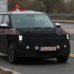 Auto camuflado circulando por una carretera en obras.