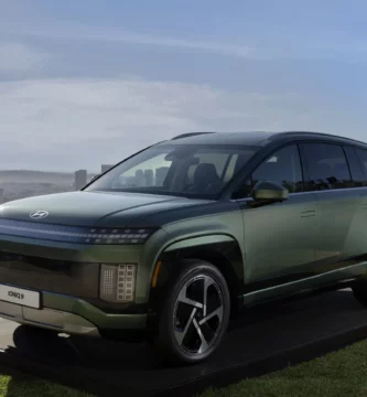 SUV verde metalizado en exhibición con paisaje urbano de fondo.