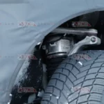 Suspensión de un automóvil con neumático de invierno visible.