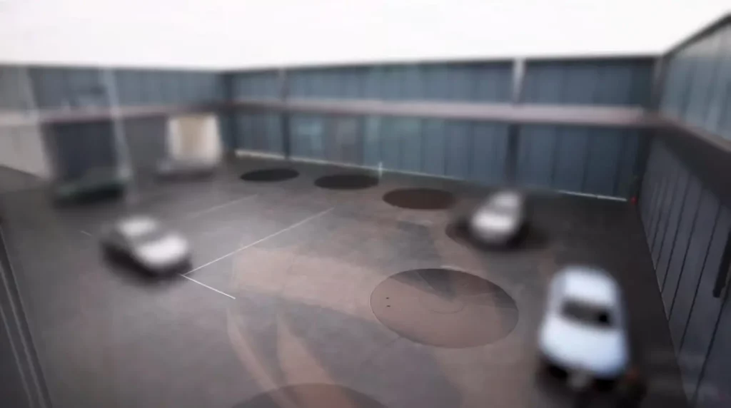 Patio con vehículos estacionados y diseño geométrico en el suelo.